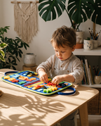 Toddler playing with the Montessori busy board at a wooden table