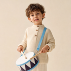 Child playing the wooden drum from the percussion music set